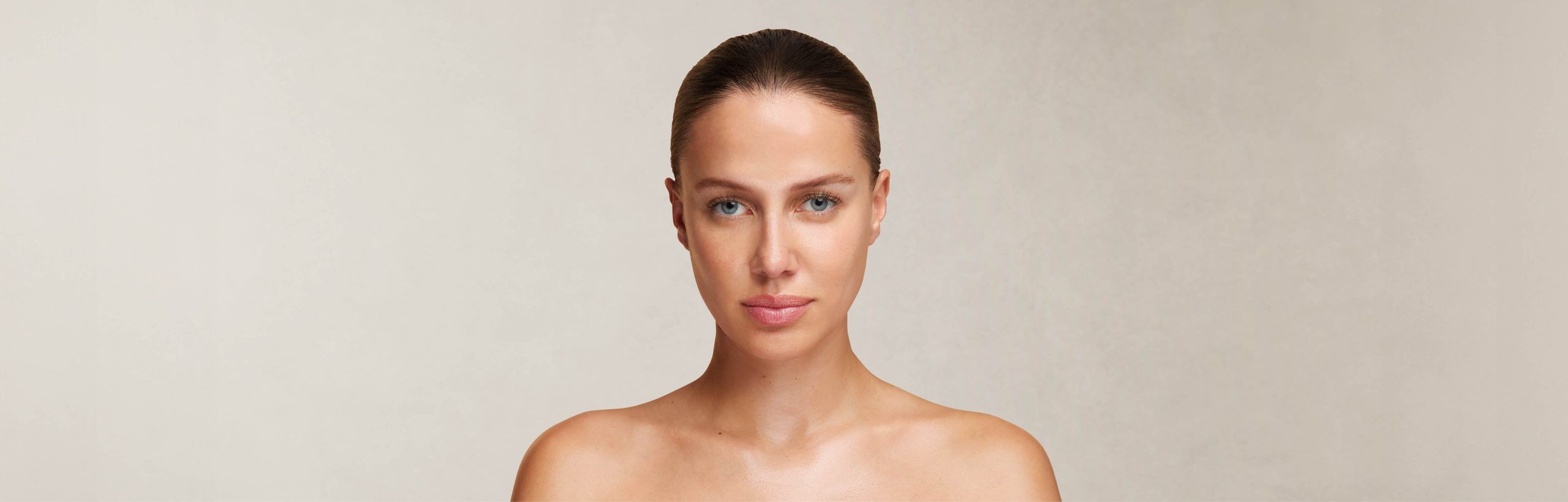 Frau mit zurückgebundenem Haar und nackten Schultern im Porträt